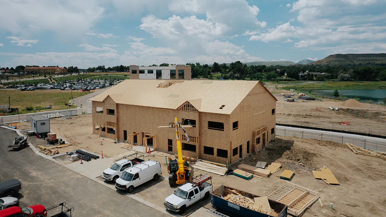 Aerial view of a large framed building at an active construction site