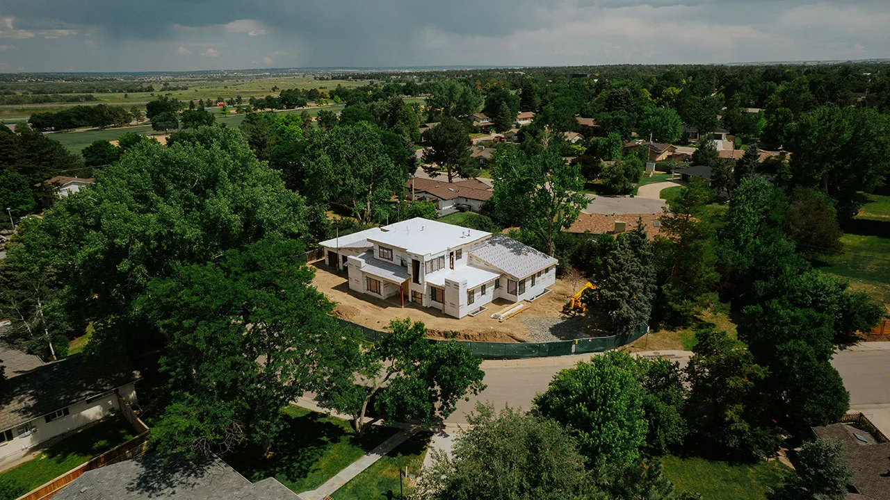 Aerial view of a custom home framed among mature trees