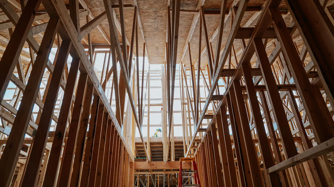 Interior view looking up through tall wall framing and upper floor joists